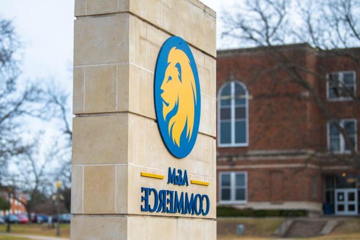 A vertical stone pillar displays the A&M-Commerce logo.